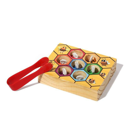 InvenToy's Montessori Bee Box with a bug-themed design features multiple colorful cavities, each containing a cartoon bug under a piece of clear plastic, and includes a red plastic tong on the side.