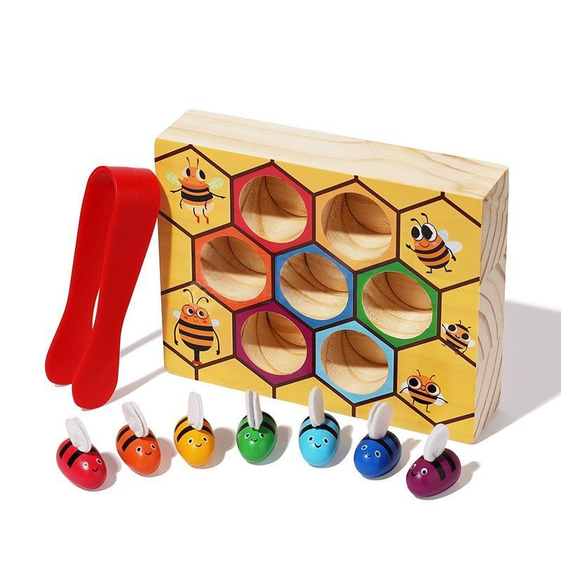 A InvenToy Montessori Bee Box featuring a box with bee illustrations and hexagonal holes, accompanied by colorful bee-shaped pieces with pull-out handles, and a red tweezer.