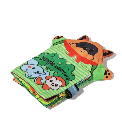 A colorful InvenToy Montessori baby cloth book with a "jungle adventure" theme, featuring cartoon illustrations of a tiger, a bear, and a rabbit on the visible page, folded and laid flat.