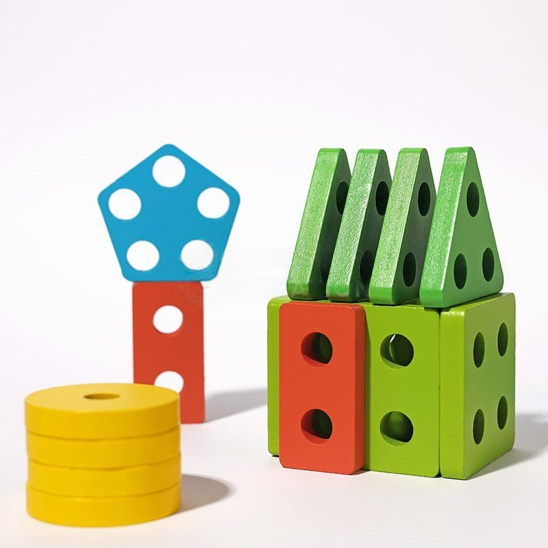 Colorful wooden InvenToy Montessori Building Blocks shaped like dice and cylinders arranged on a white background, illustrating a playful stack of geometric forms.