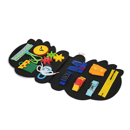 An educational toy featuring a Montessori Dino Busy Board with various colorful buckles, zippers, laces, and buttons designed to help children develop fine motor skills. This InvenToy merges play with skill.