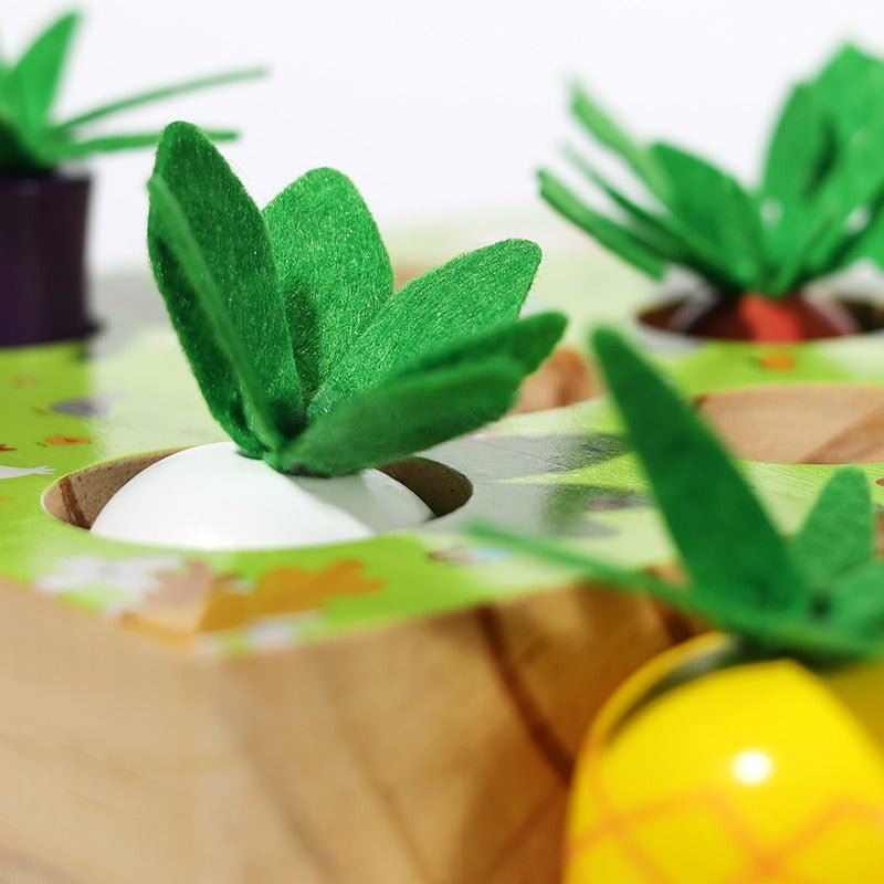 Close-up of a wooden tray with cubbies holding InvenToy's Montessori Vegetable Set shaped like Easter eggs decorated like carrots with green felt leaves and yellow patterned eggs. A creative and colorful holiday craft display.