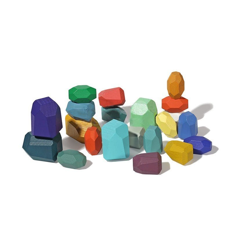 A collection of colorful, wooden InvenToy Montessori Wooden Stones (21 Pieces) in various geometric shapes, scattered on a white background.
