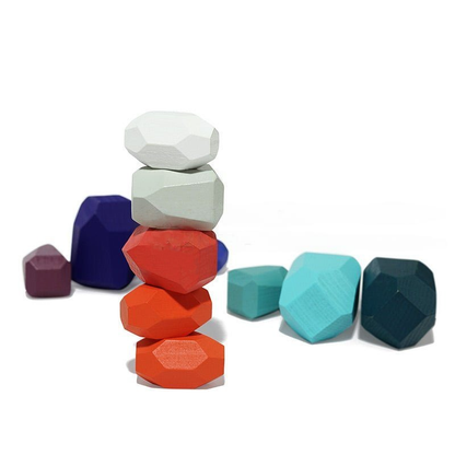 A stack of colorful, geometrically shaped InvenToy Montessori Wooden Stones (21 Pieces) in a staggered formation on a white background, with additional blocks scattered around the base.