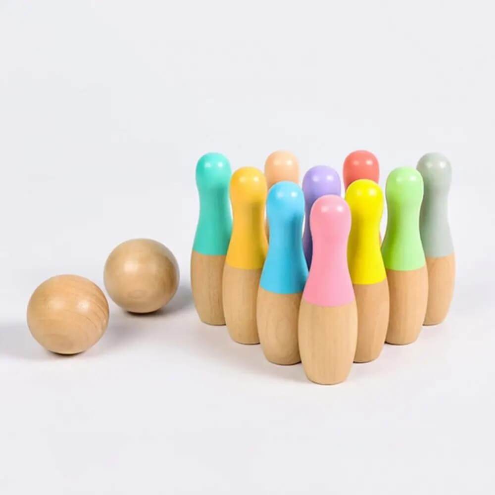 A set of wooden InvenToy Montessori Bowling Set on a white background. The pins are painted in various vibrant colors at the top, with natural wood bases. Two wooden balls are placed separately.