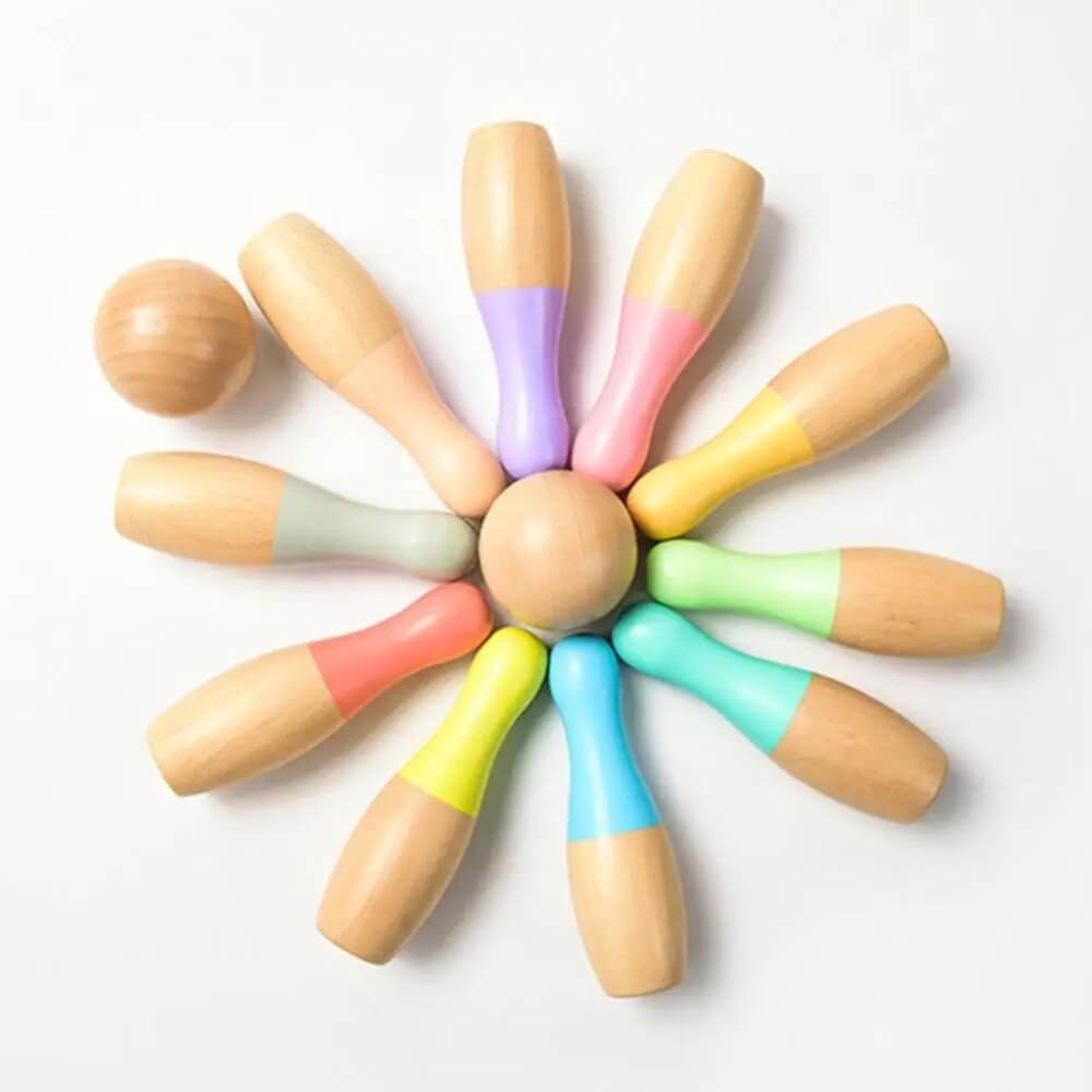 A InvenToy Montessori Bowling Set, consisting of a wooden ball surrounded by eight wooden pins arranged in a radial pattern like a flower, each pin capped with different pastel colors, against a white background.