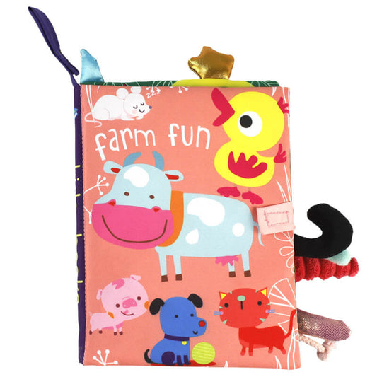 Colorful InvenToy Montessori Baby Soft Book titled "Farm Fun" with illustrations of a cow, duck, pig, and other animals, plus various textured tags and a yellow crinkly element.